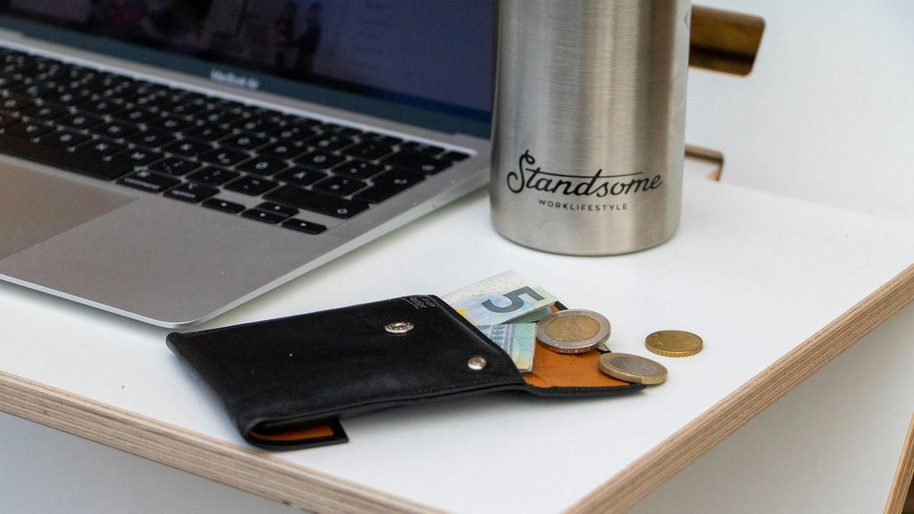 Wallet next to a laptop, representing ad budget being spent