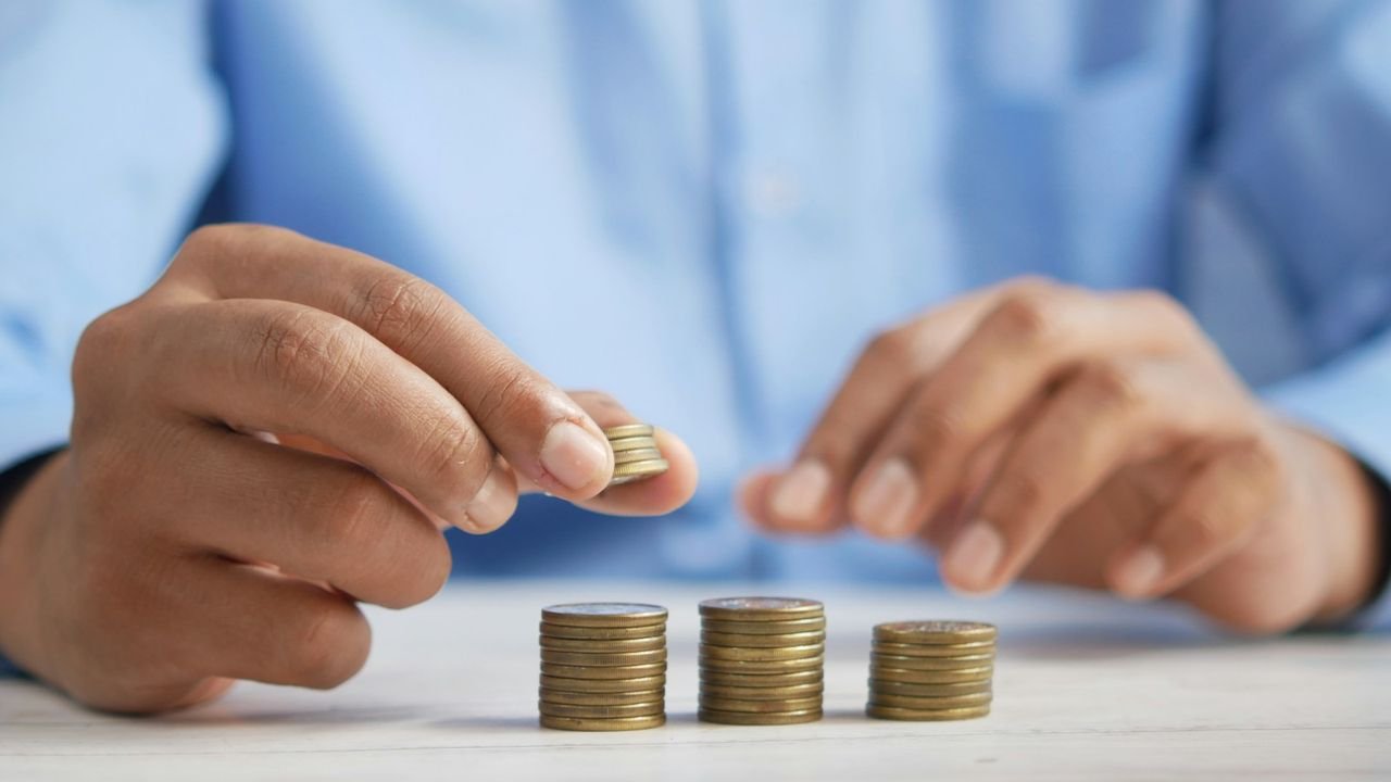 Person stacking coins on a table, representing cleaning prices