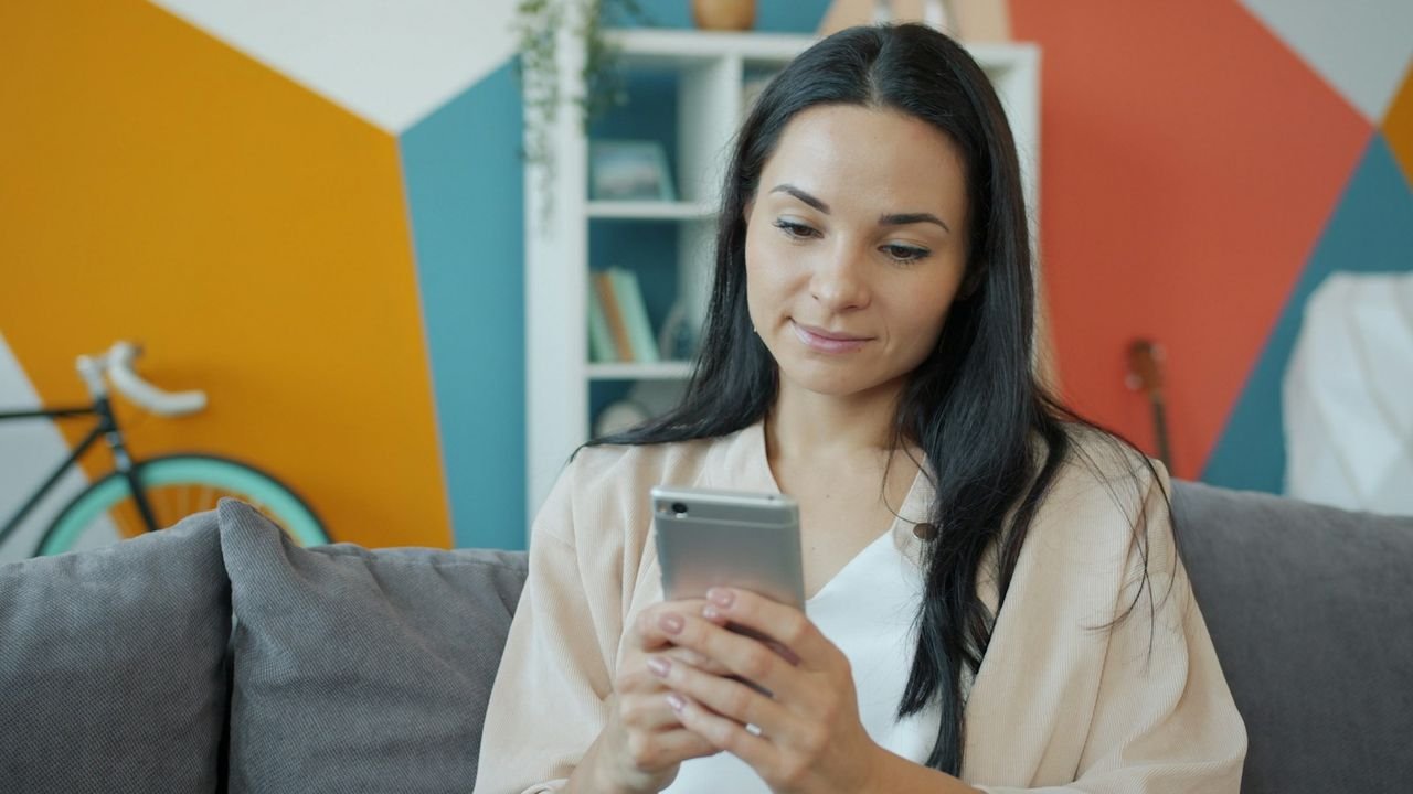 Woman on a couch searching for local services on her smartphone