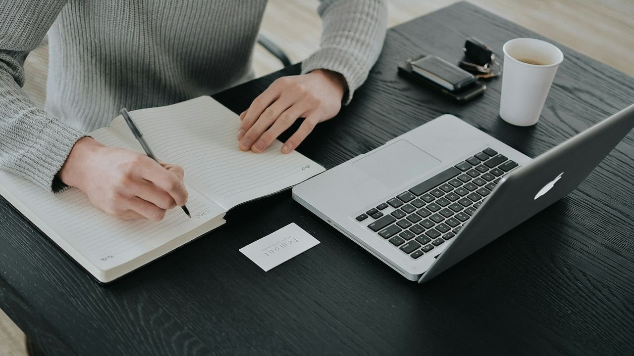Person writing a lead response plan in a notebook at a desk