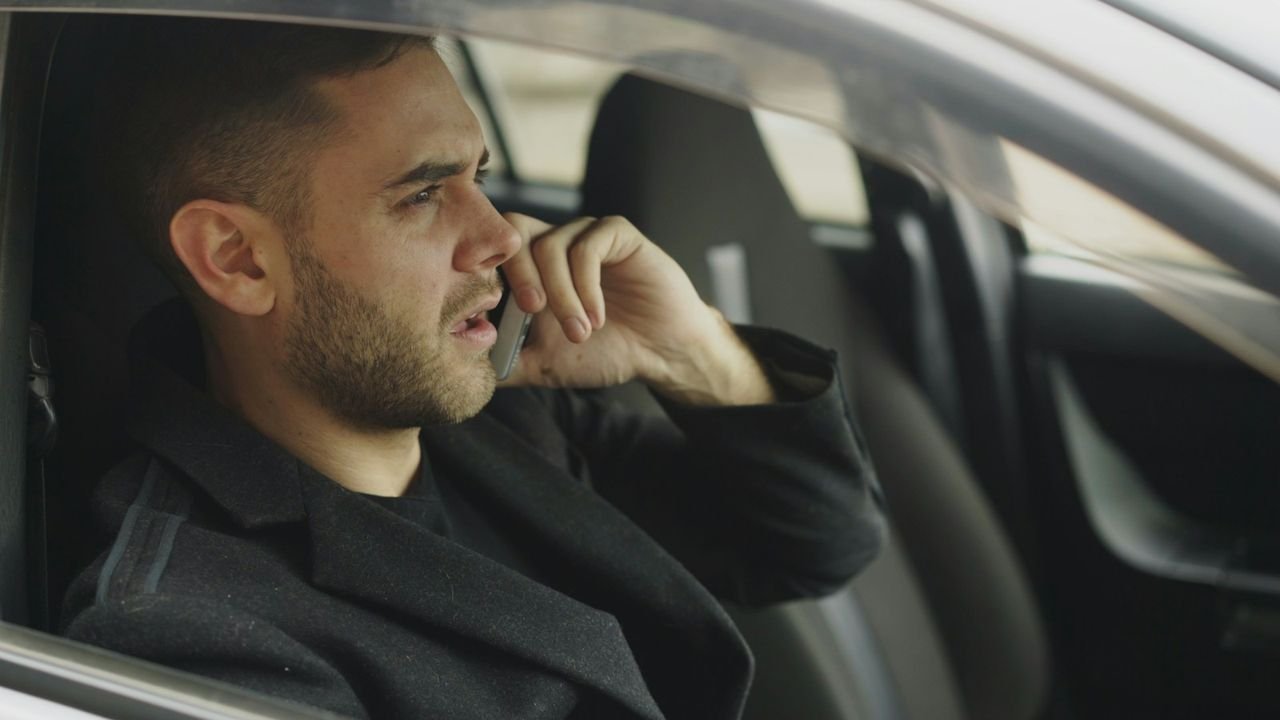 Business owner in his car taking a call from a new lead