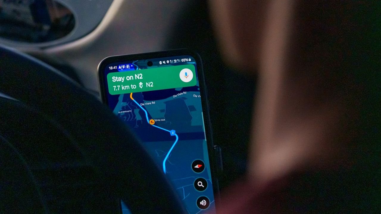 Person using a maps app on a smartphone in a car