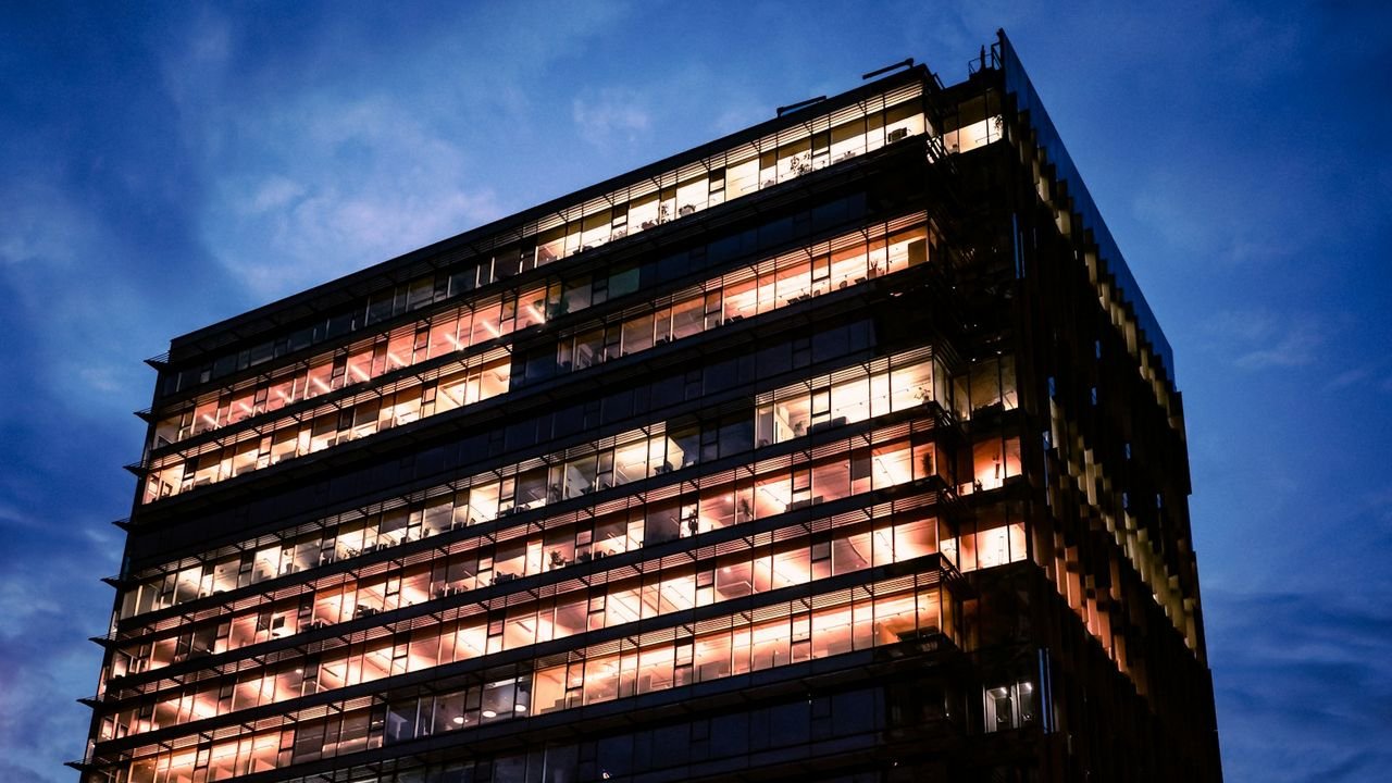 Modern office building with lit windows in the evening