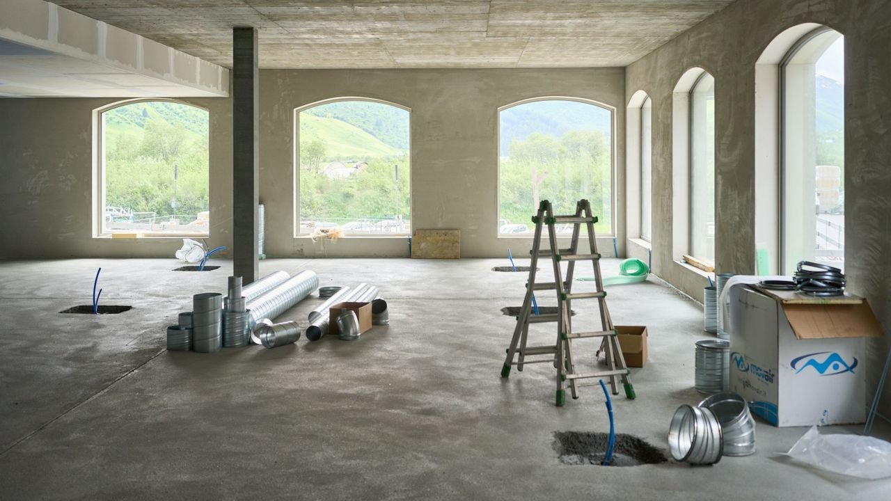 Large newly built room with windows and a ladder