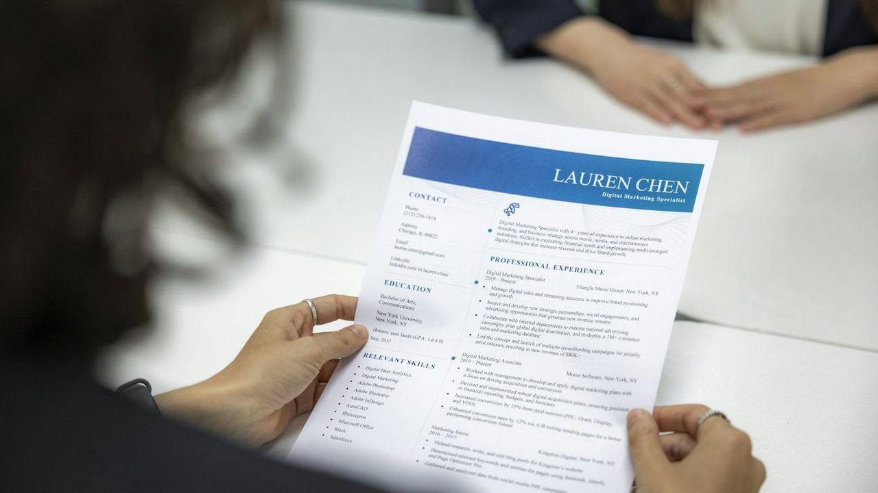Woman reviewing a job applicant's resume at a table