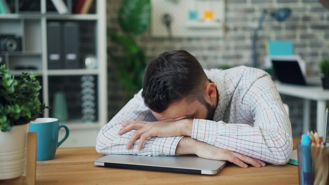 Stressed business owner at a desk with his head in his hands