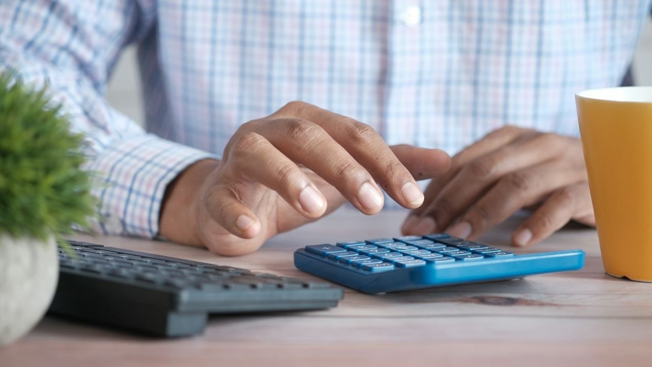 Person using a calculator at a desk to work out cost per lead