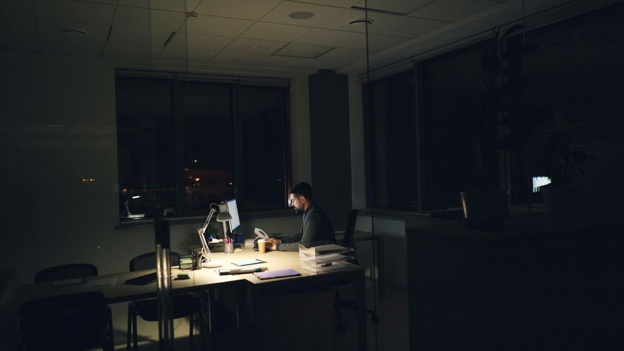 Business owner working late on a website at a dimly lit desk